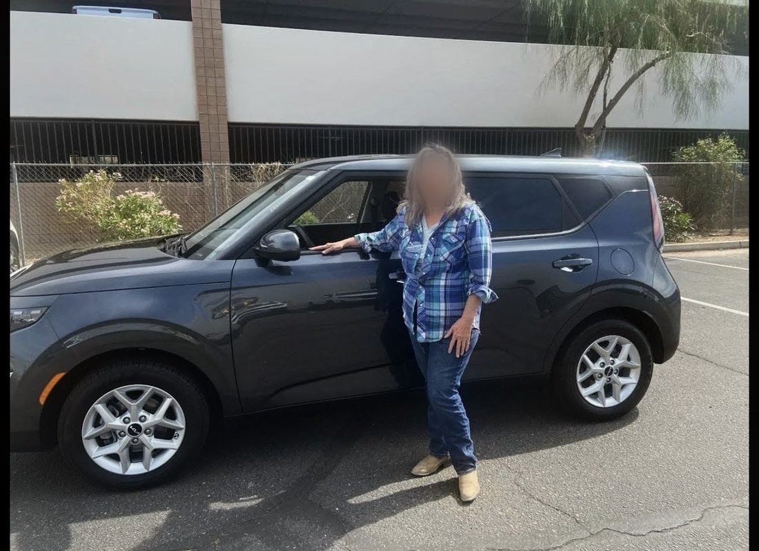 A recipient standing beside the car she received through the Automobile Program